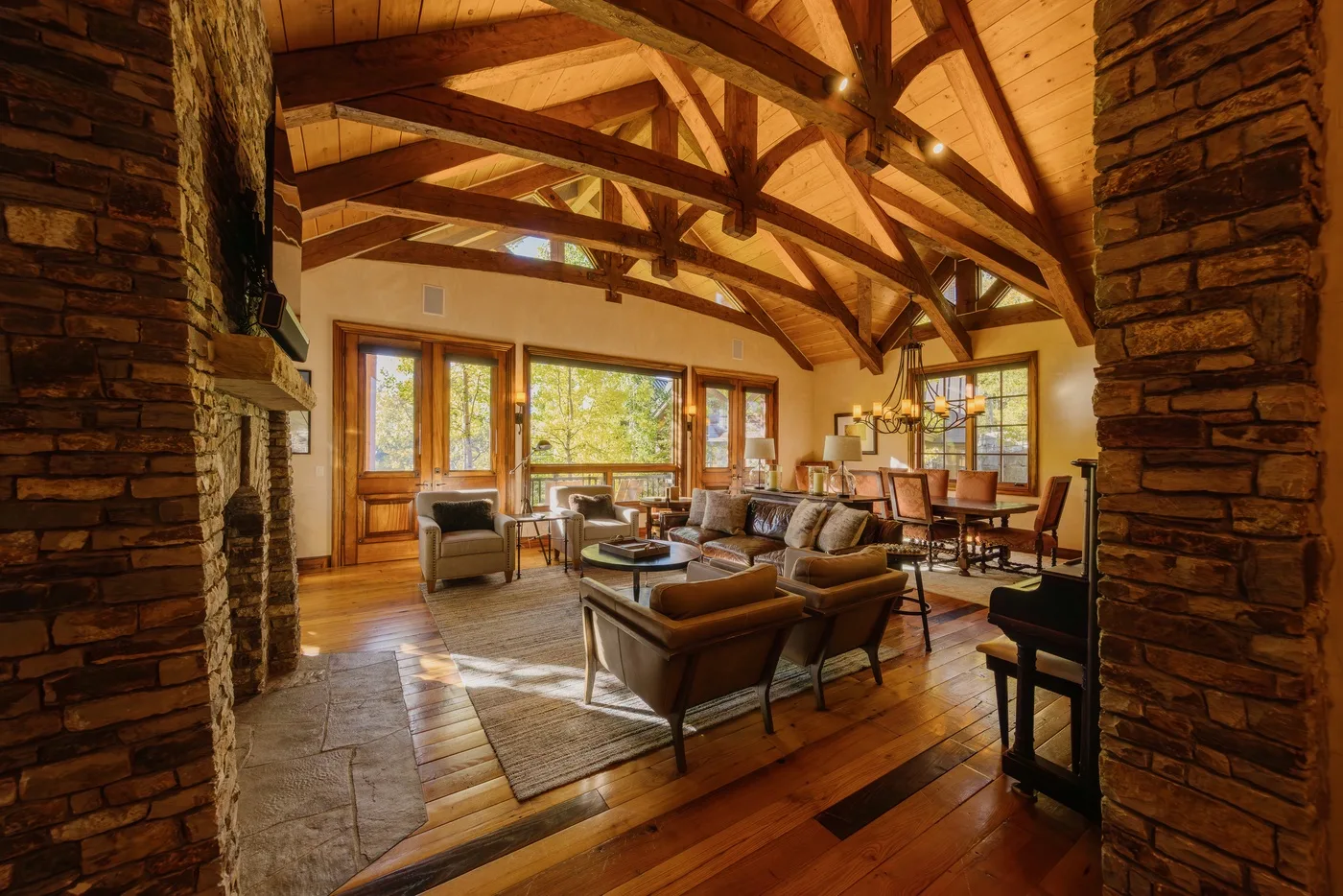 A spacious living room with seating beneath exposed wooden ceiling beams.