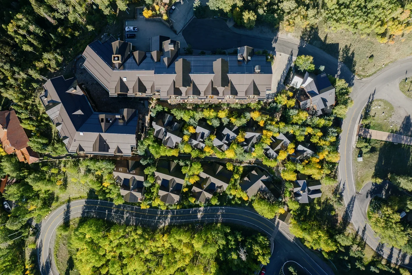 An aerial view of a large building surrounded by trees and landscaped grounds.