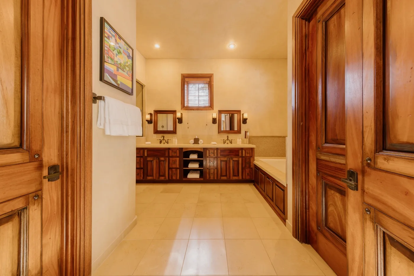 A bathroom with a long vanity, two sinks, and a tiled floor.