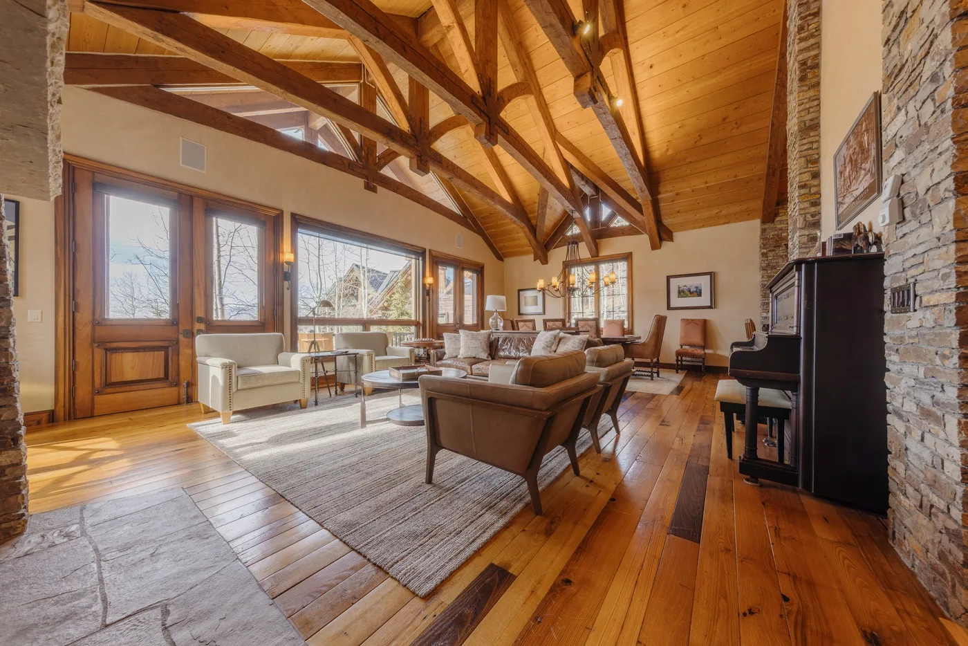A bright living room with seating beneath a high wooden ceiling.