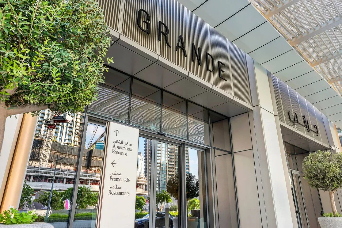 A modern building entrance with glass doors and a prominent GRANDE sign.