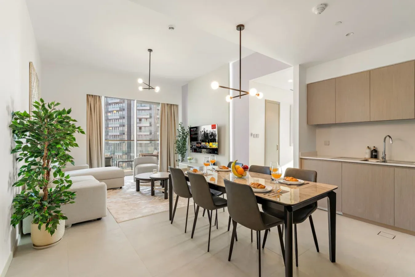 An open-plan living, dining, and kitchen area with a dining table in the foreground.