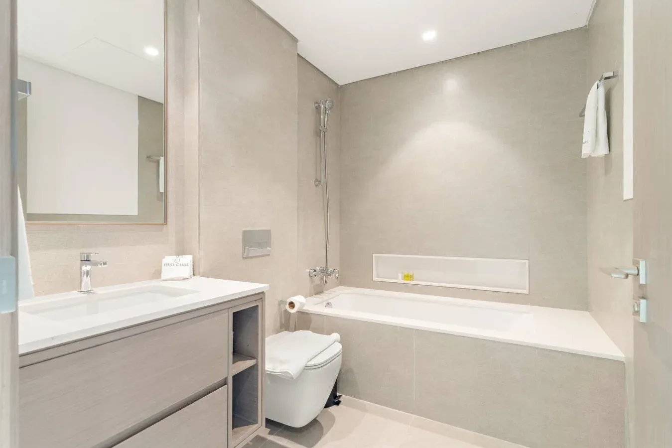 A bathroom with a vanity, toilet, and bathtub.