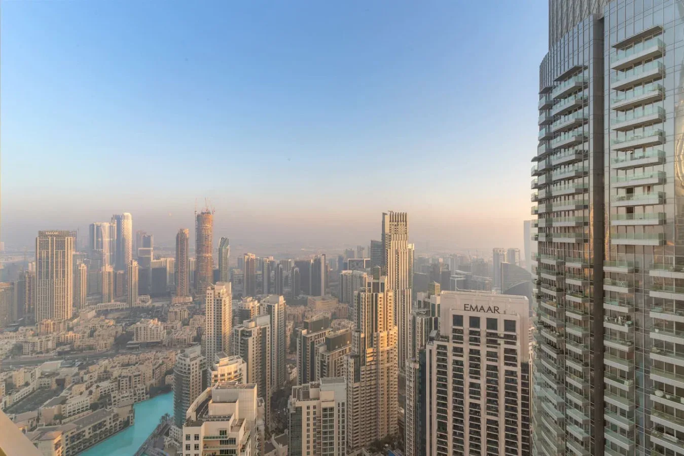 A city skyline viewed from above, with high-rise buildings beneath a clear sky.