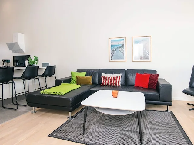A living room with seating, a coffee table, and a dining area.