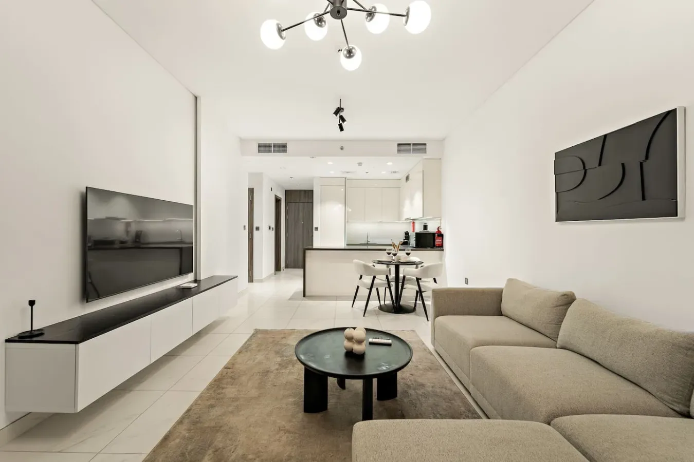 A bright living room with a television, seating, and a dining table.