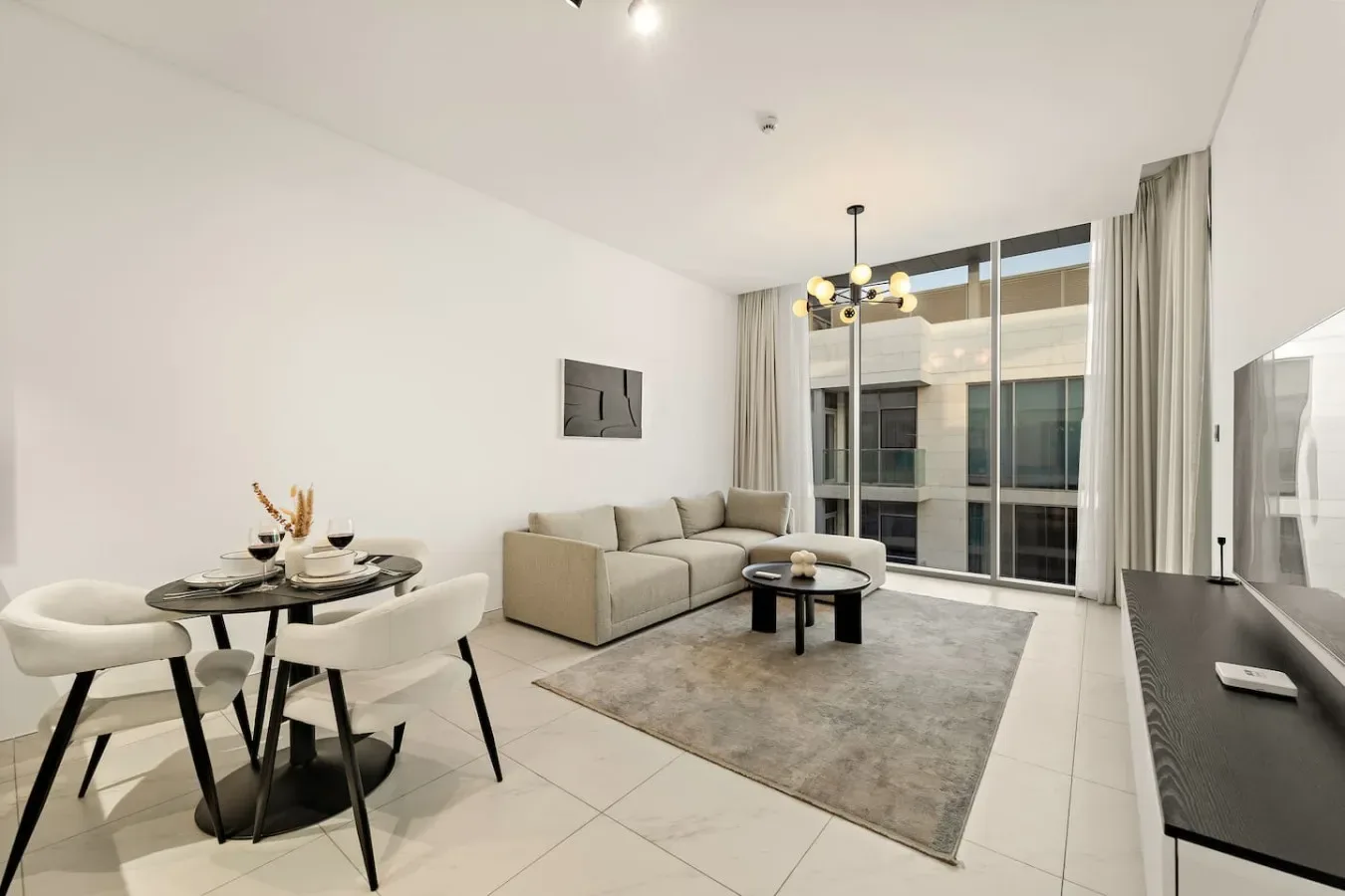 Una luminosa sala de estar con mesa de comedor y asientos junto a grandes ventanales.