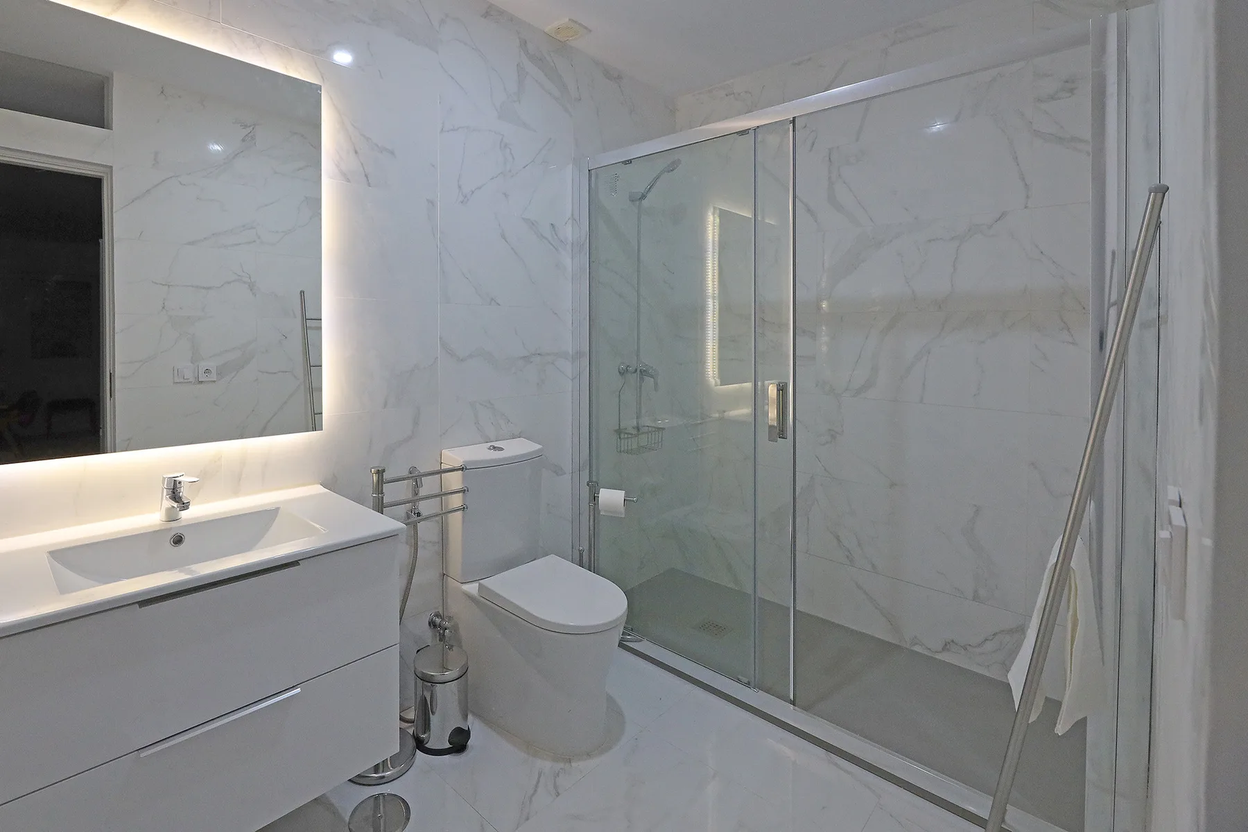 A bathroom with a sink, toilet, and glass shower.
