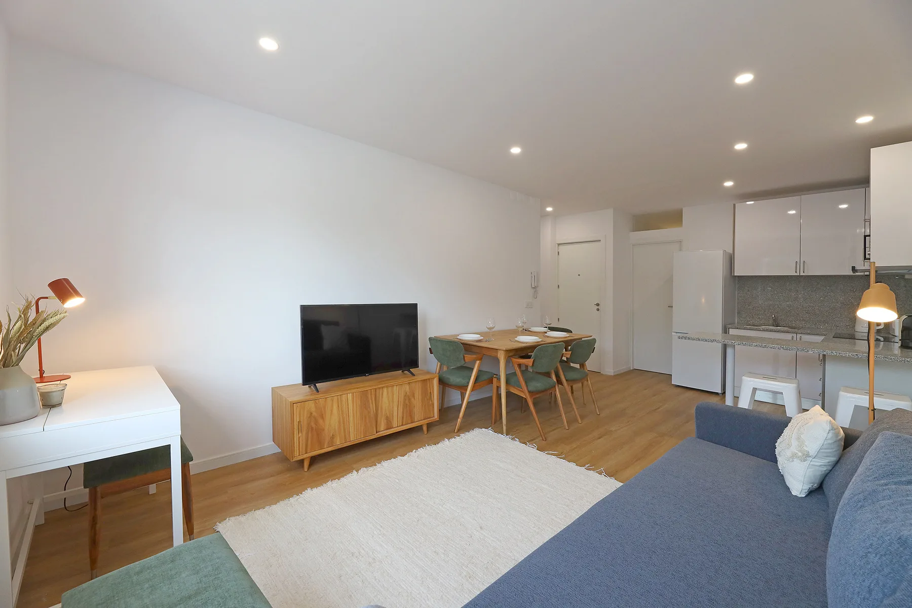 An open-plan living and dining area with a television and kitchen.