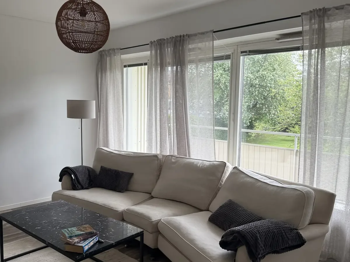 Sala de estar con sofá y una gran pared acristalada — apartamento en Storgatan 16C