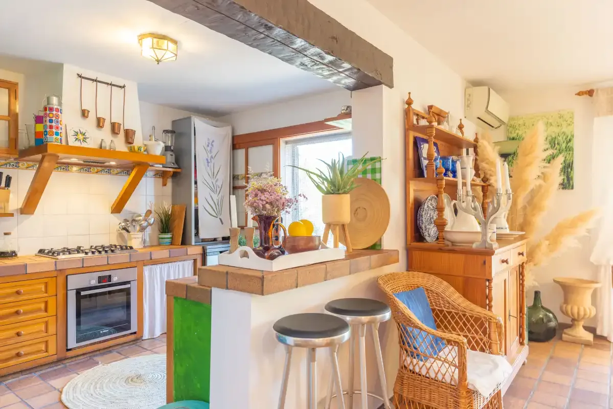 An open kitchen and dining area with a counter and wicker seating.
