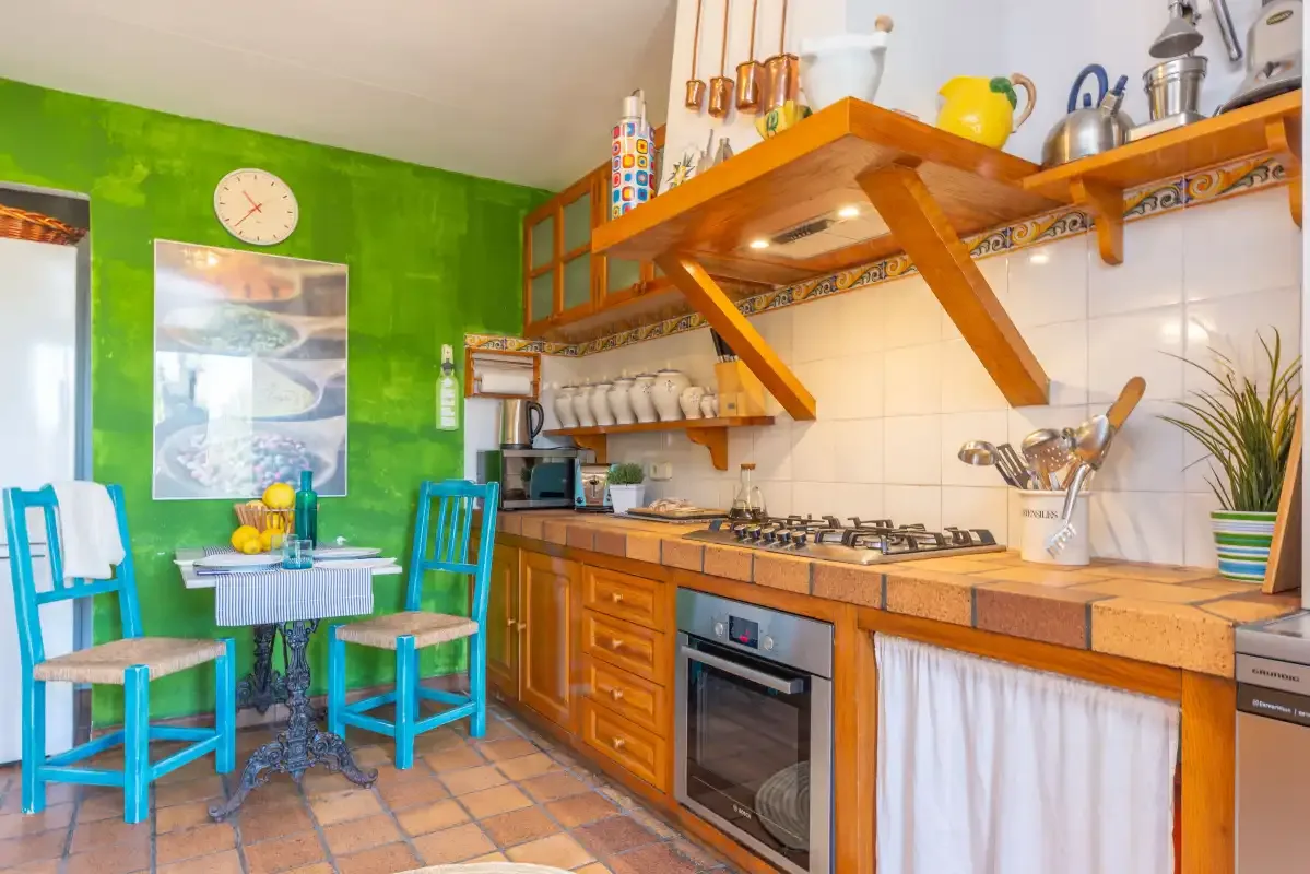 A colorful kitchen with a dining table and wooden cabinets.