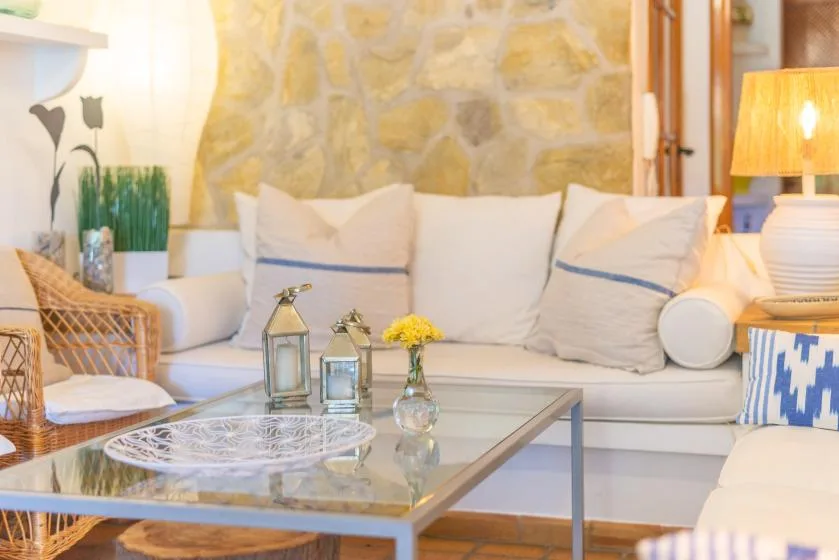 A bright living room with cushioned seating around a glass coffee table.