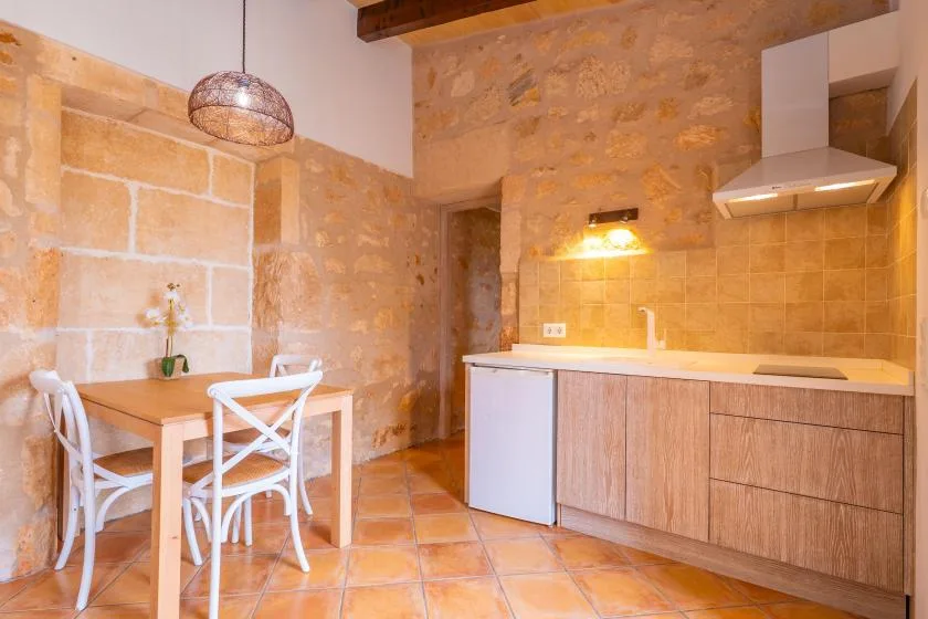 Una cocina rústica con una mesa de comedor y un mostrador con frentes de madera.