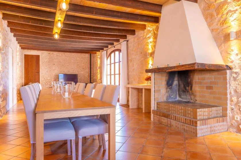 Un comedor con una mesa larga y una chimenea grande.