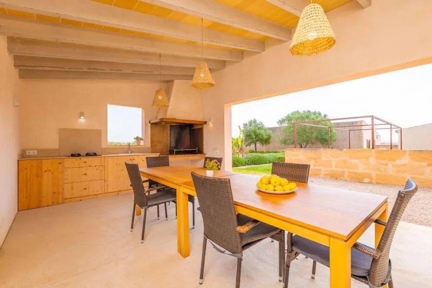 Comedor con una mesa larga y vistas abiertas al jardín.