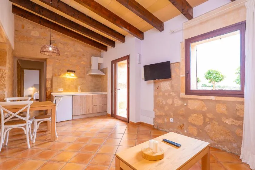 Una sala de estar y cocina de estilo rústico con vigas de madera vistas en el techo.