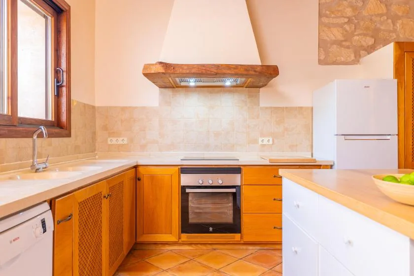 Una cocina con gabinetes de madera, una encimera y un horno.
