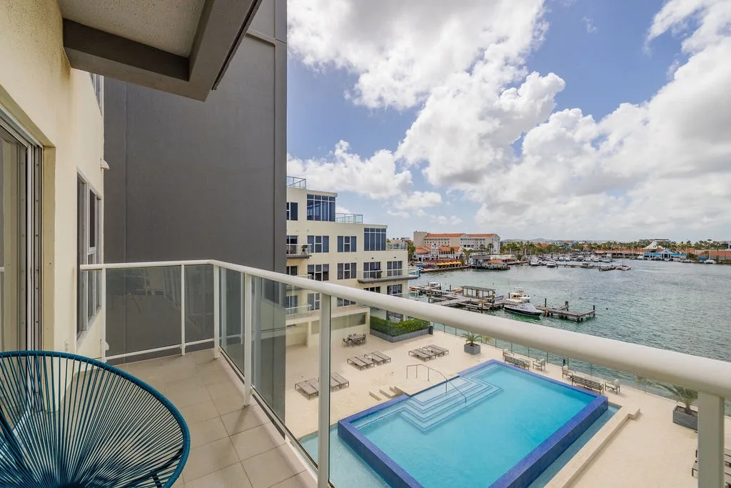 Sip your morning coffee on your private balcony overlooking the sparkling pool, waterfront marina, and vibrant cityscape beyond.