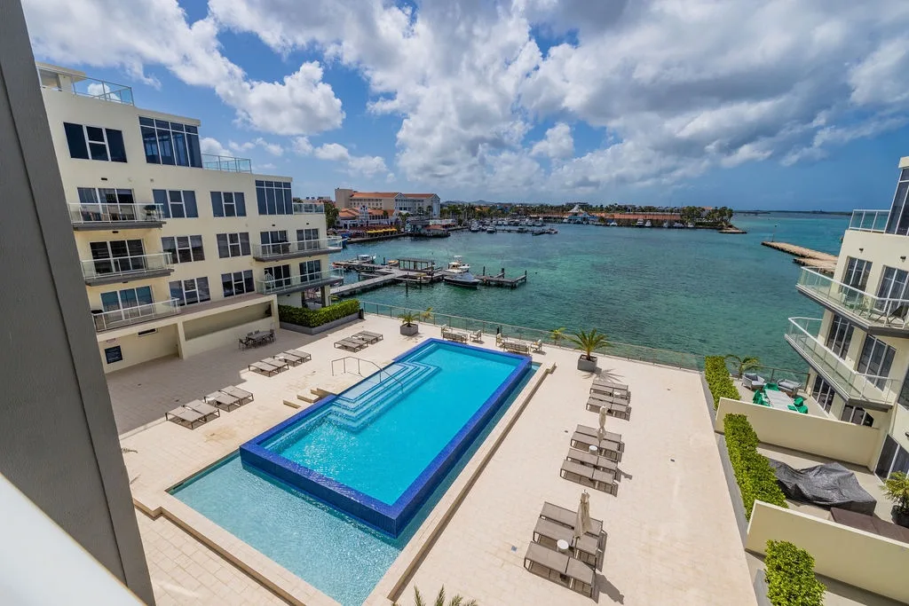 Modern waterfront property features a stunning pool deck with marina views