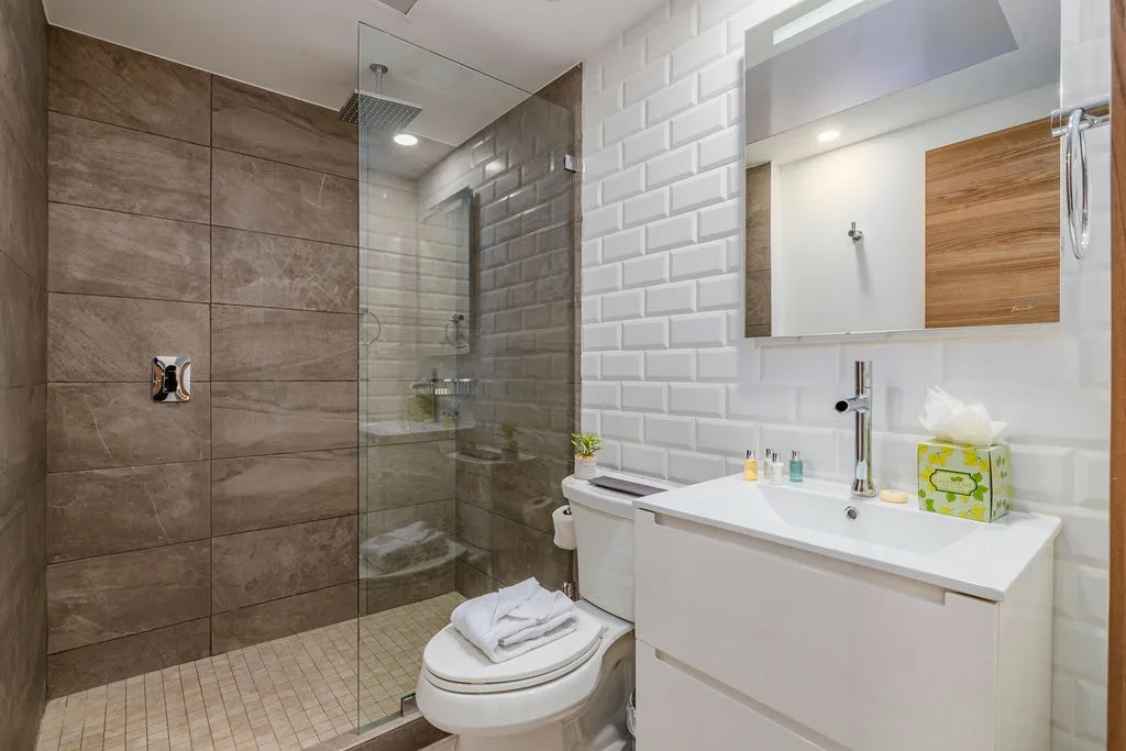 Refresh in your private bathroom with modern tile work, a spacious walk-in shower