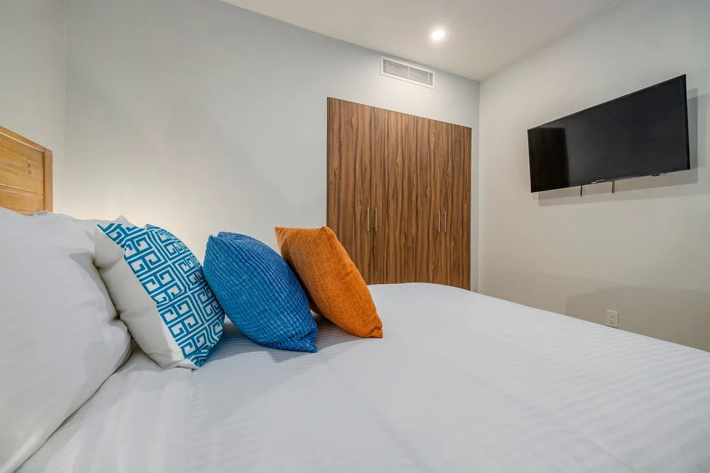 Sink into crisp linens and colorful pillows in your private retreat, complete with a flat-screen TV and generous wardrobe for all your belongings.