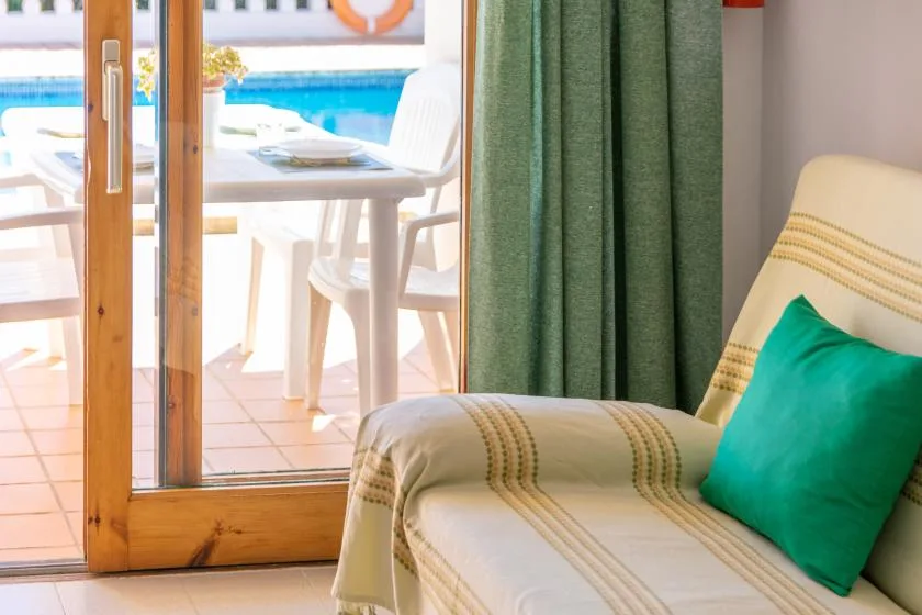 A seating area beside sliding glass doors opens onto a poolside patio.