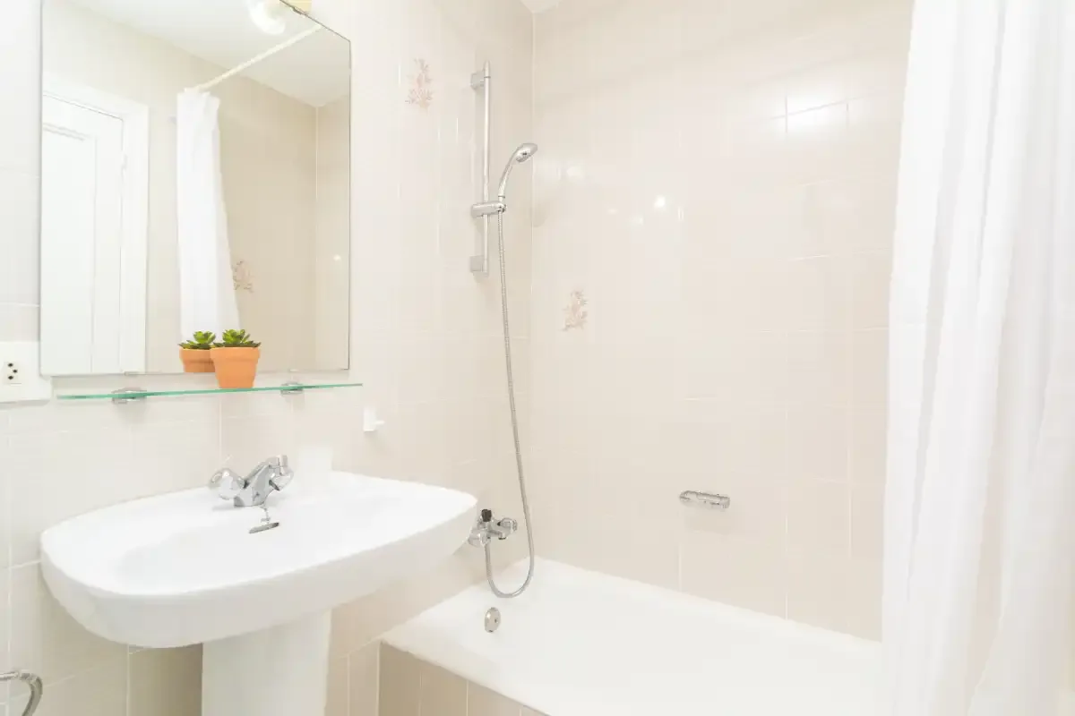 A bright bathroom with a sink and shower.