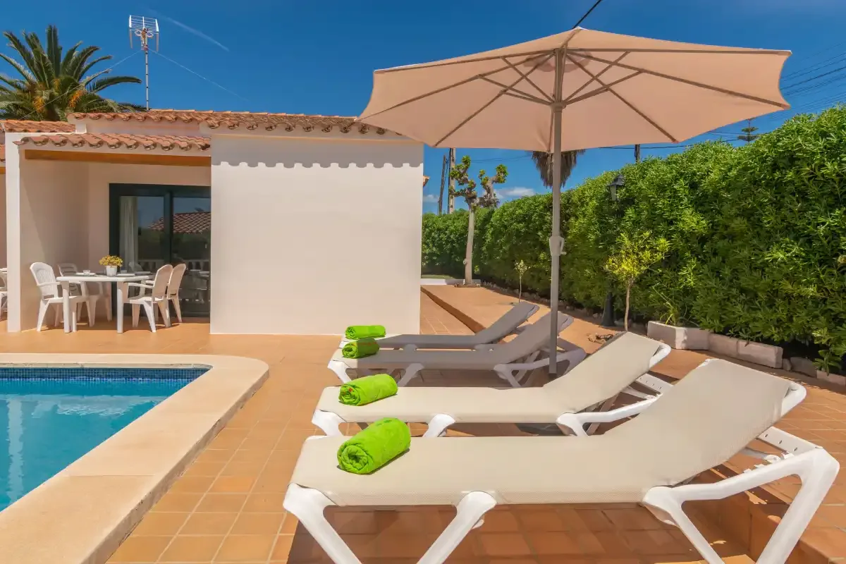 A sunny poolside patio with lounge seating and an outdoor dining area.