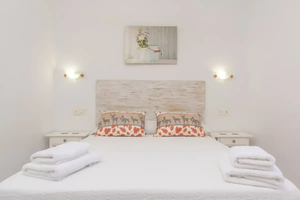 A bedroom with a neatly made bed and matching bedside tables.