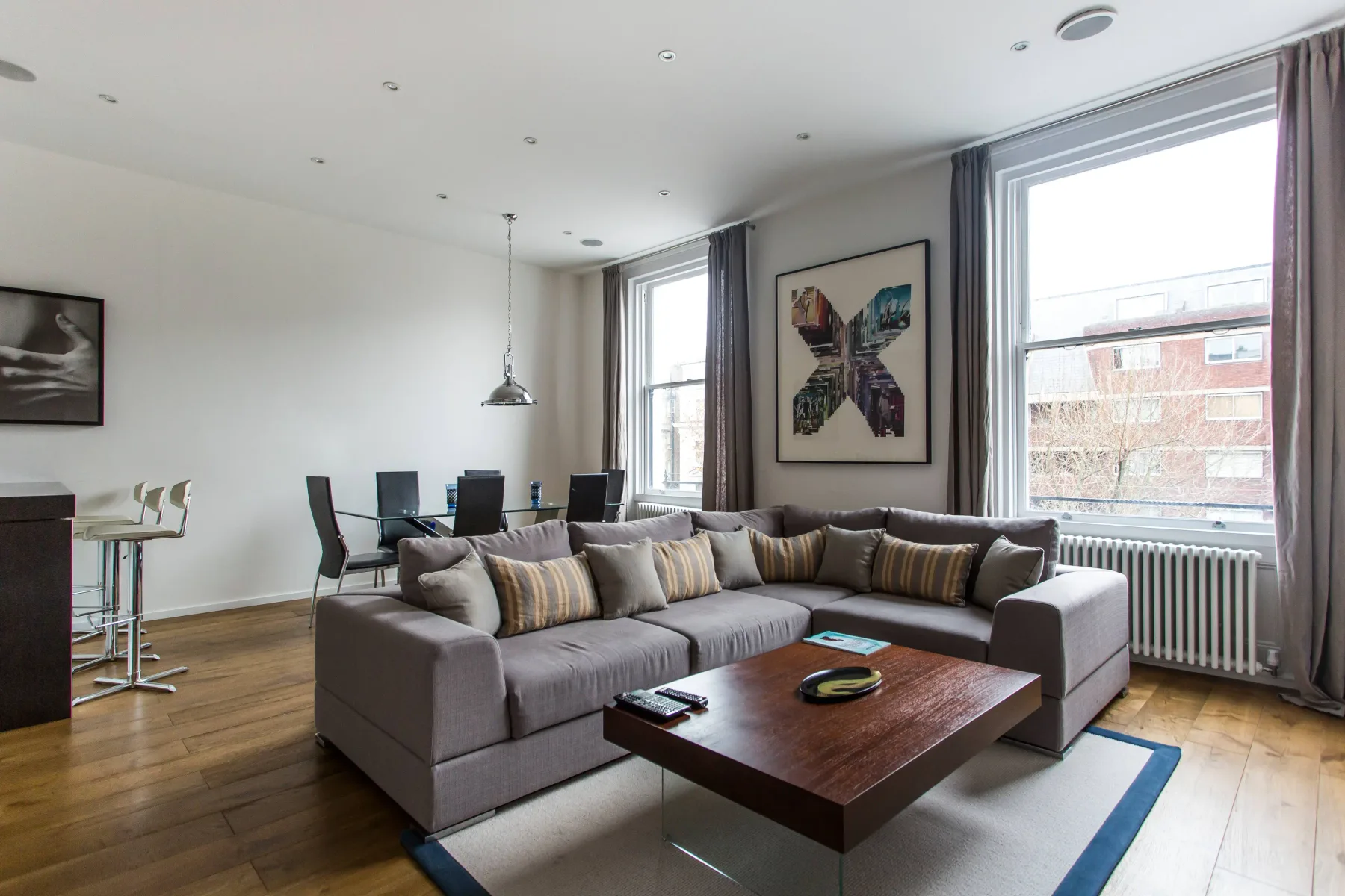 Una sala luminosa con una zona de asientos junto a grandes ventanas.