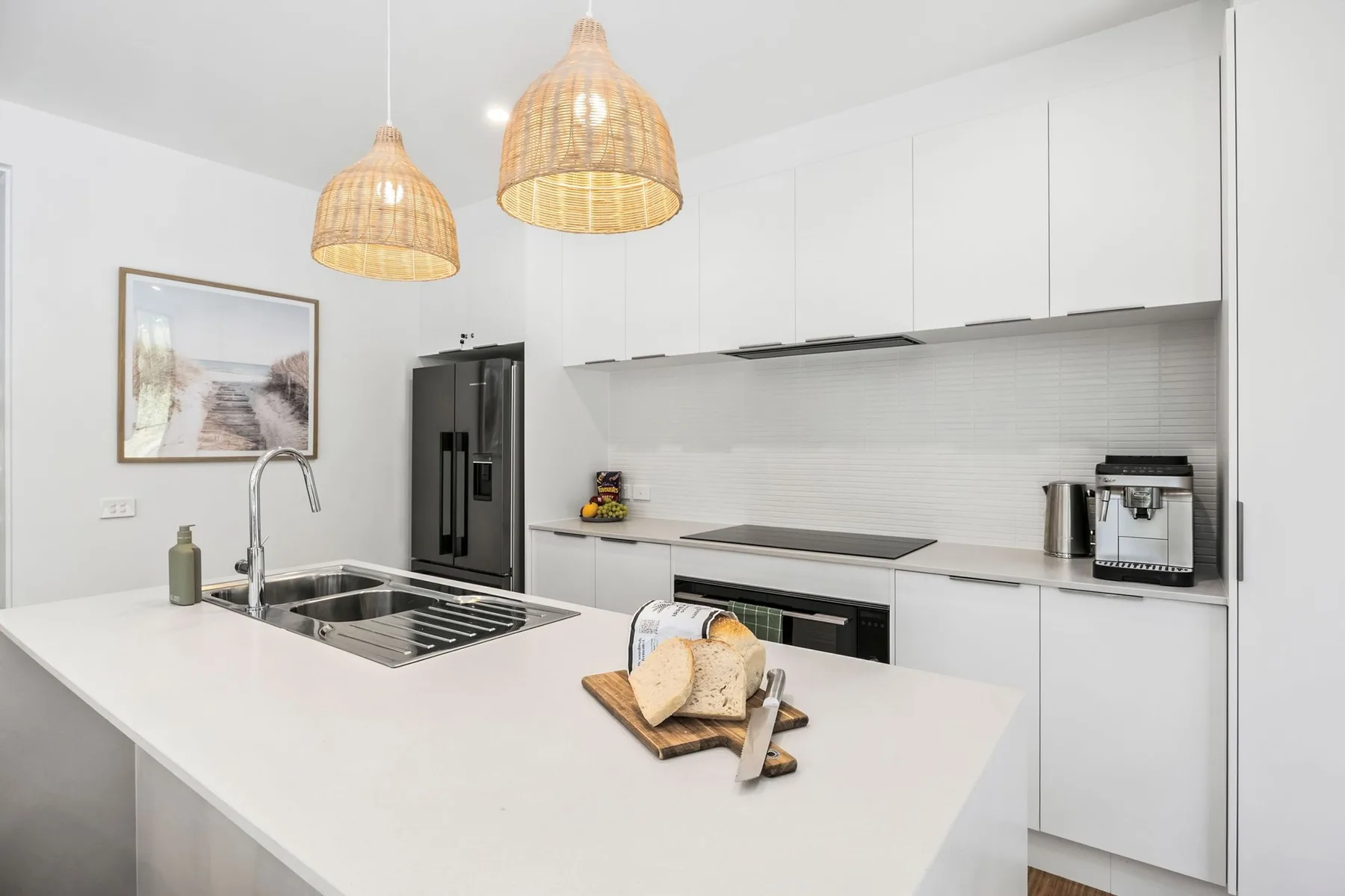 Una cocina luminosa con una isla grande y lámparas colgantes.