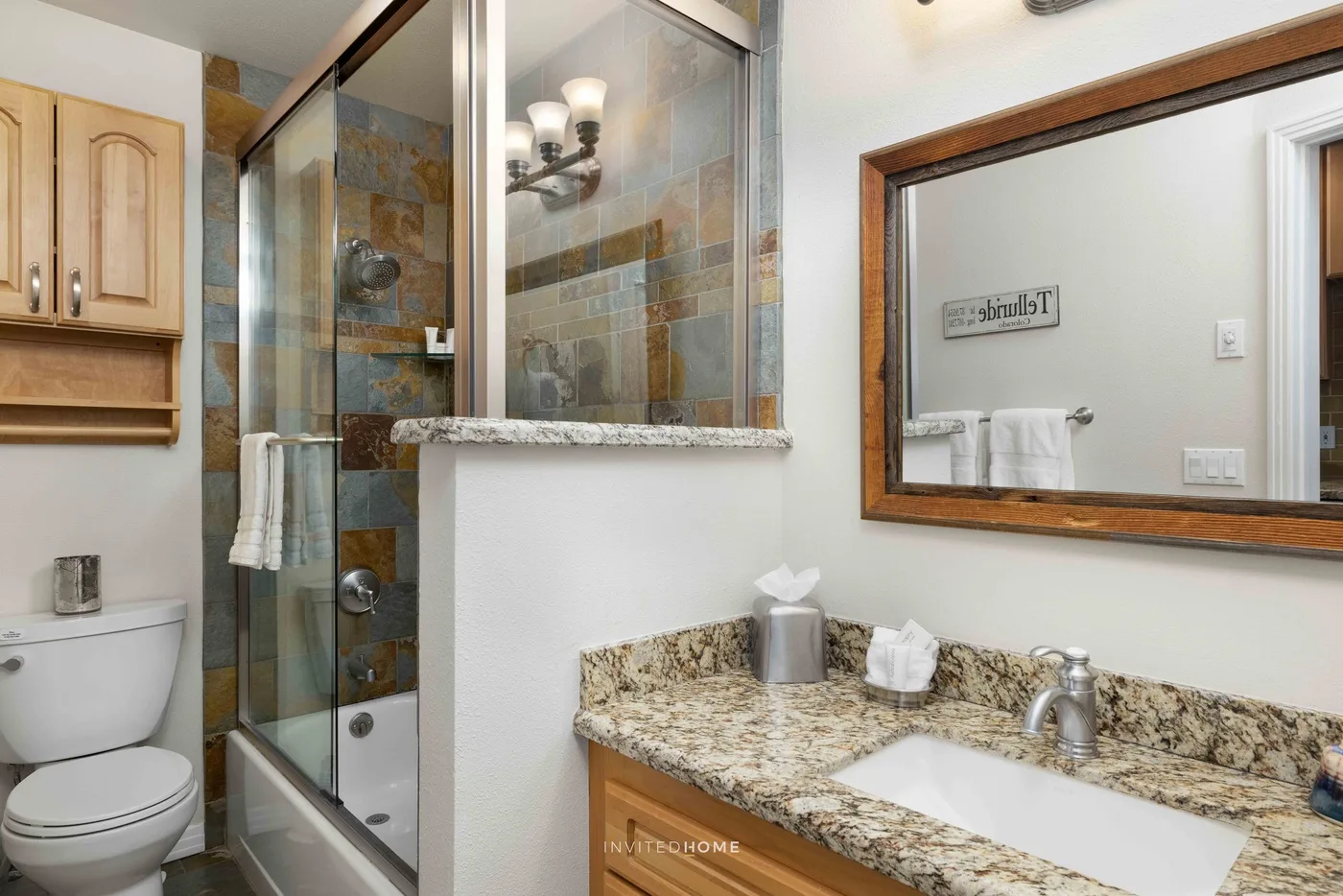 Un baño con una ducha de vidrio y una encimera junto al lavabo.