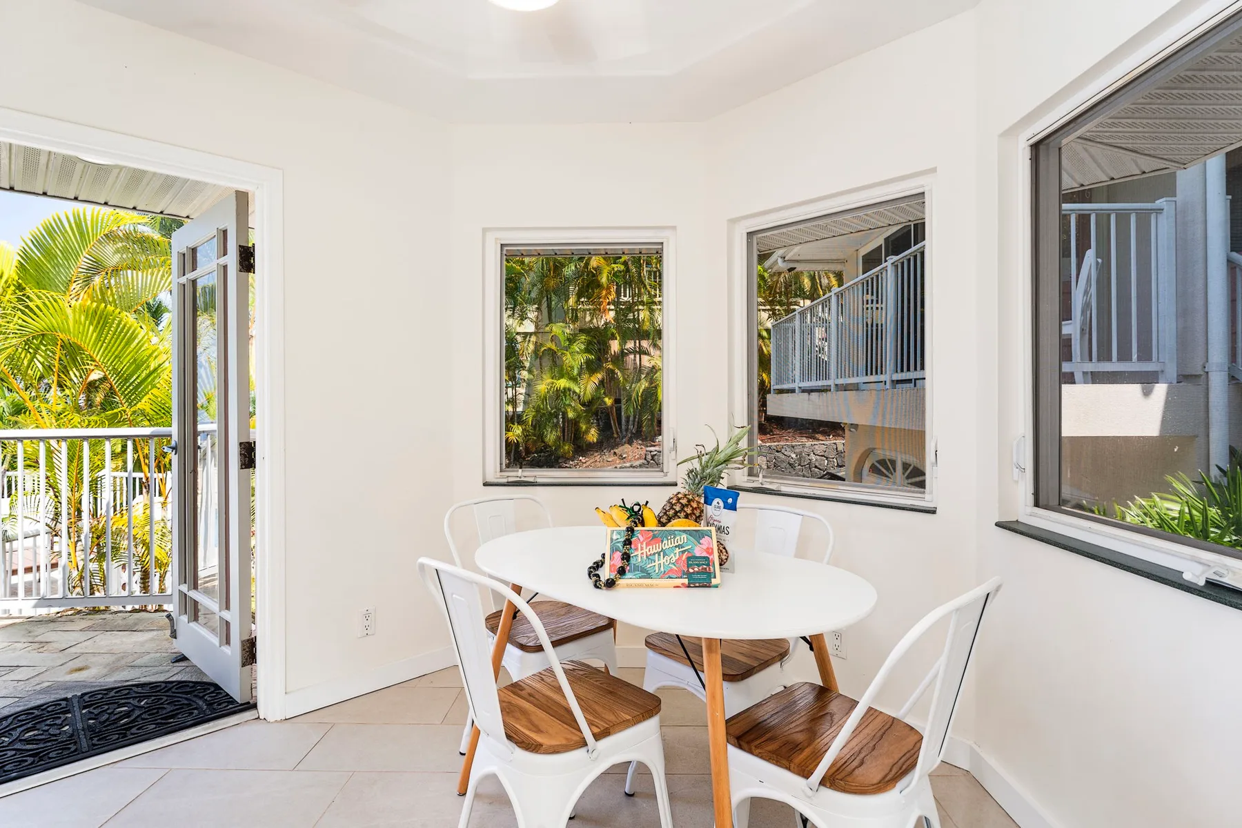 Un comedor luminoso con una mesa redonda y ventanas con vistas a la vegetación.