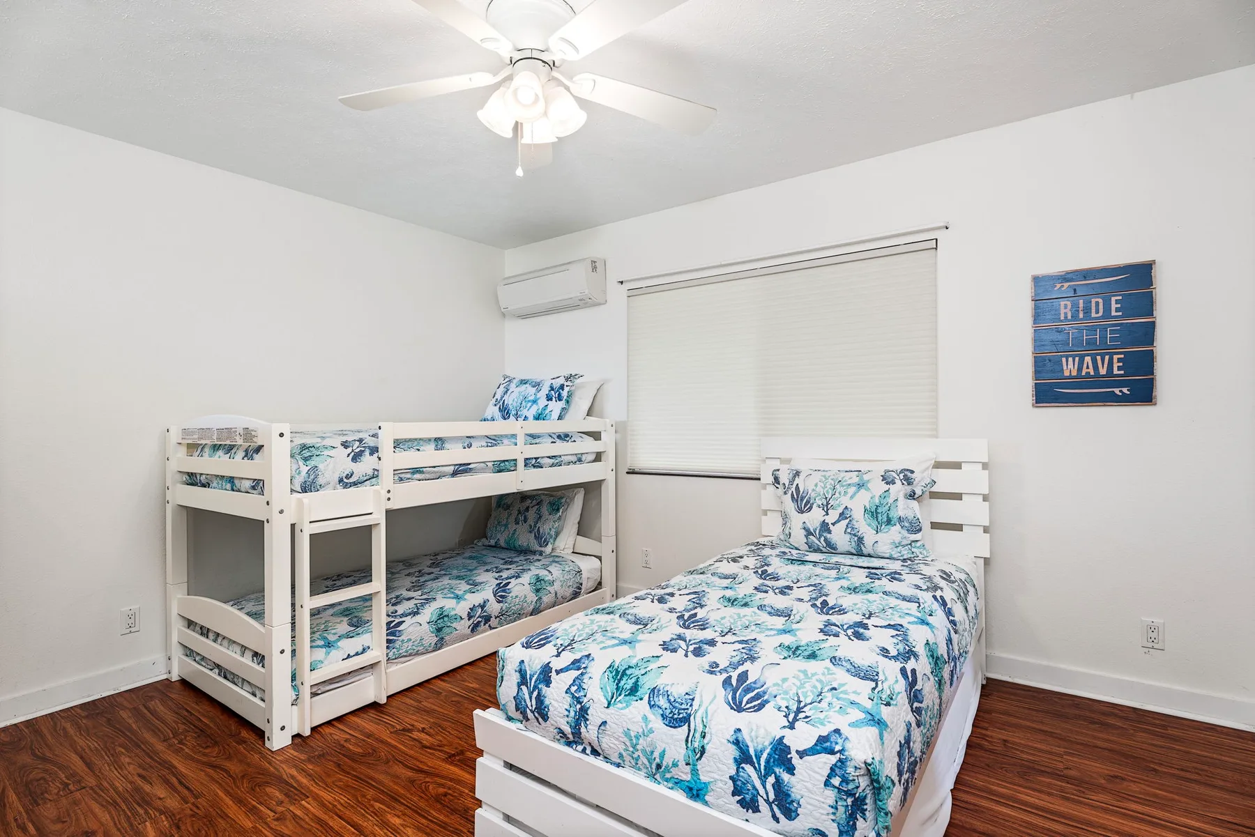 Un dormitorio con camas blancas vestidas con ropa de cama floral azul.