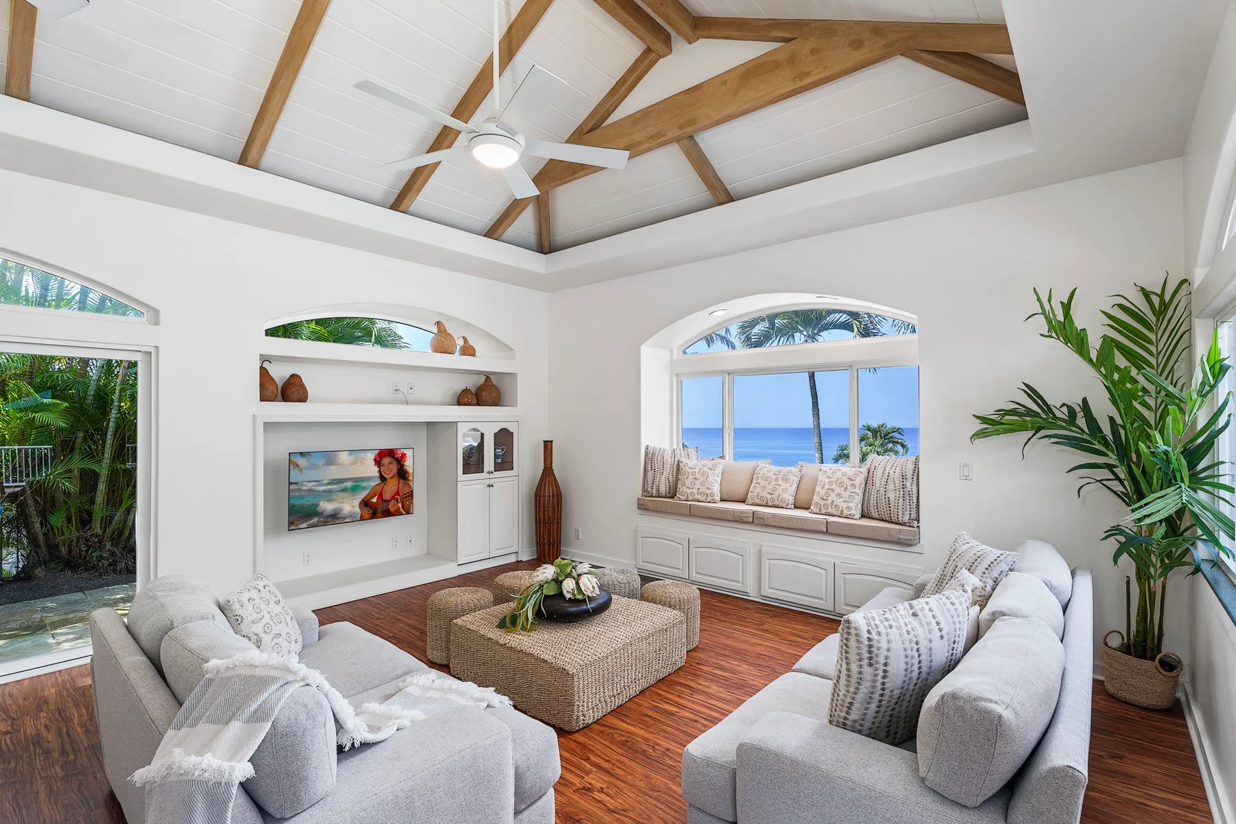 Una sala luminosa con asientos, una ventana amplia y un techo con vigas de madera.
