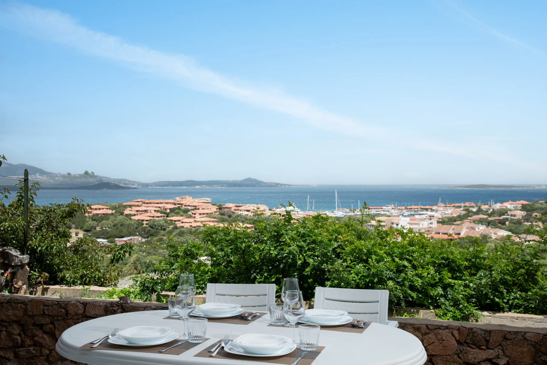 Una mesa de comedor al aire libre ofrece vistas de edificios costeros y el mar.