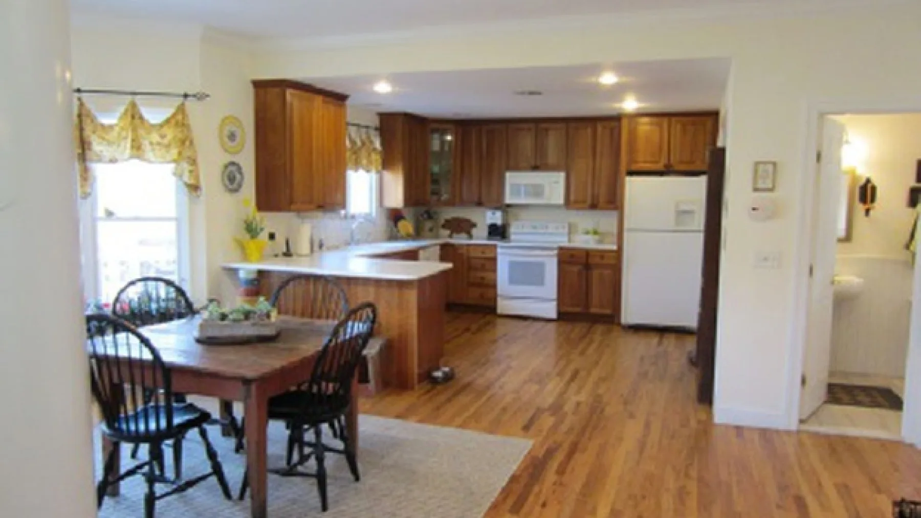An open kitchen and dining area with wooden cabinets and a table.