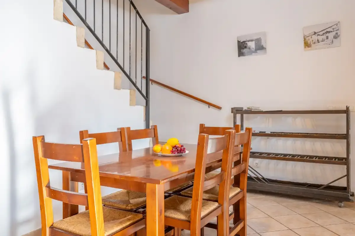 A dining area with wooden seating beneath a staircase.