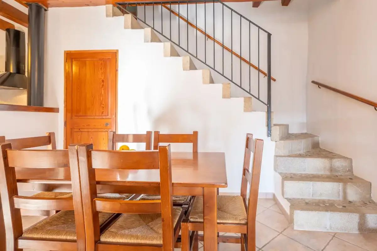 A dining area with wooden seating beside a staircase.