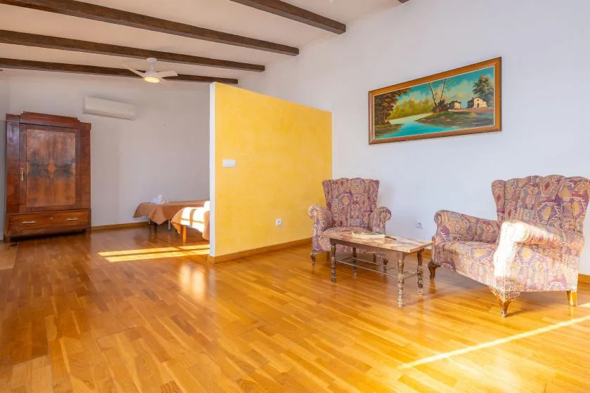 A sitting area with patterned seating and a low table beside a yellow partition.
