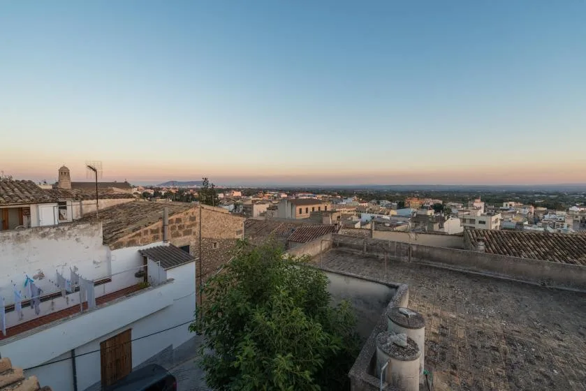A rooftop view overlooks a town beneath a clear evening sky.