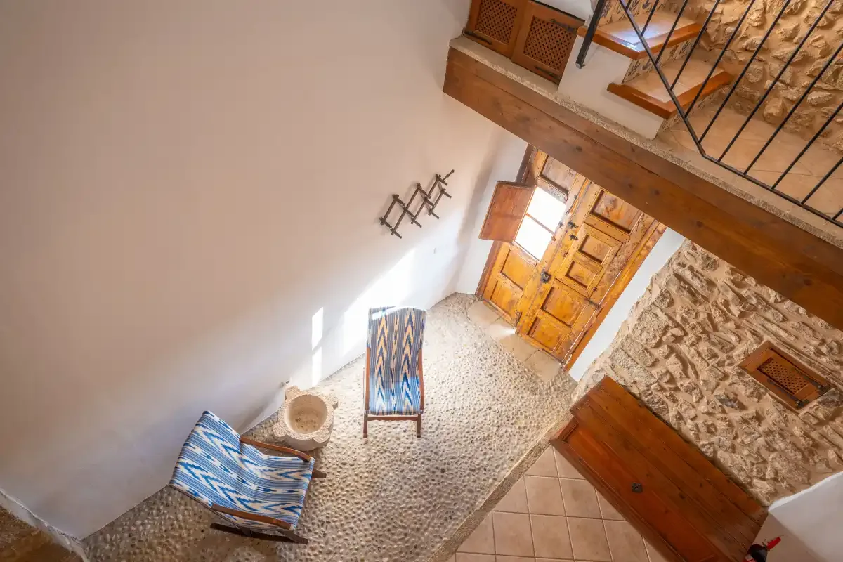An interior entryway with a wooden door and staircase.