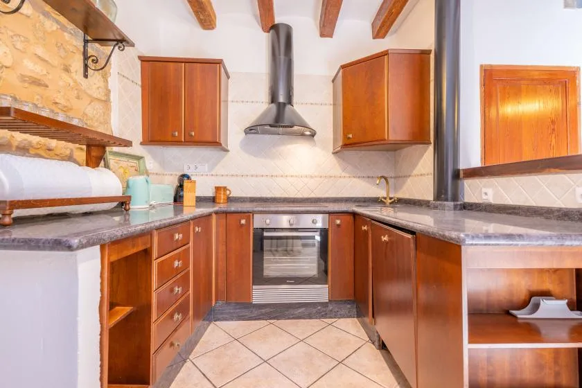 A kitchen with wooden cabinets, a countertop, and a built-in oven.