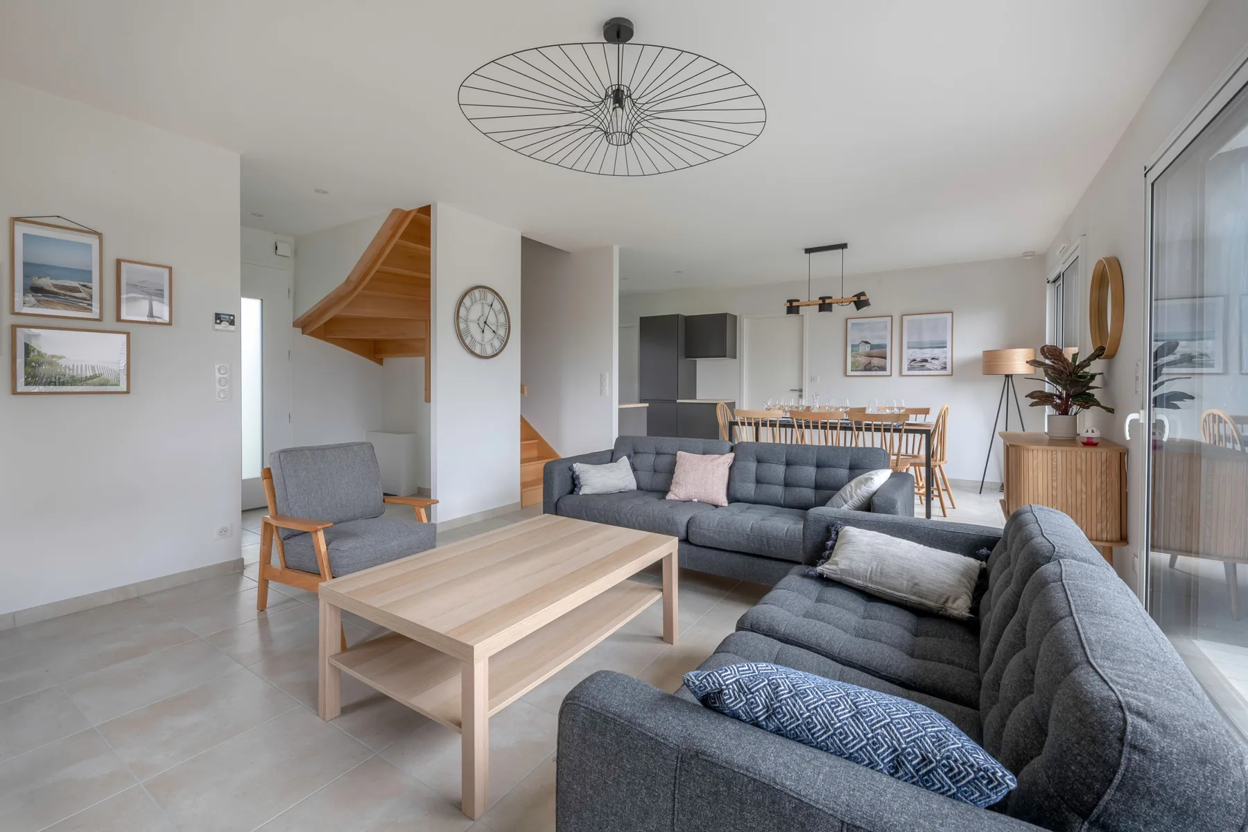 A bright living room with gray seating and a wooden coffee table.