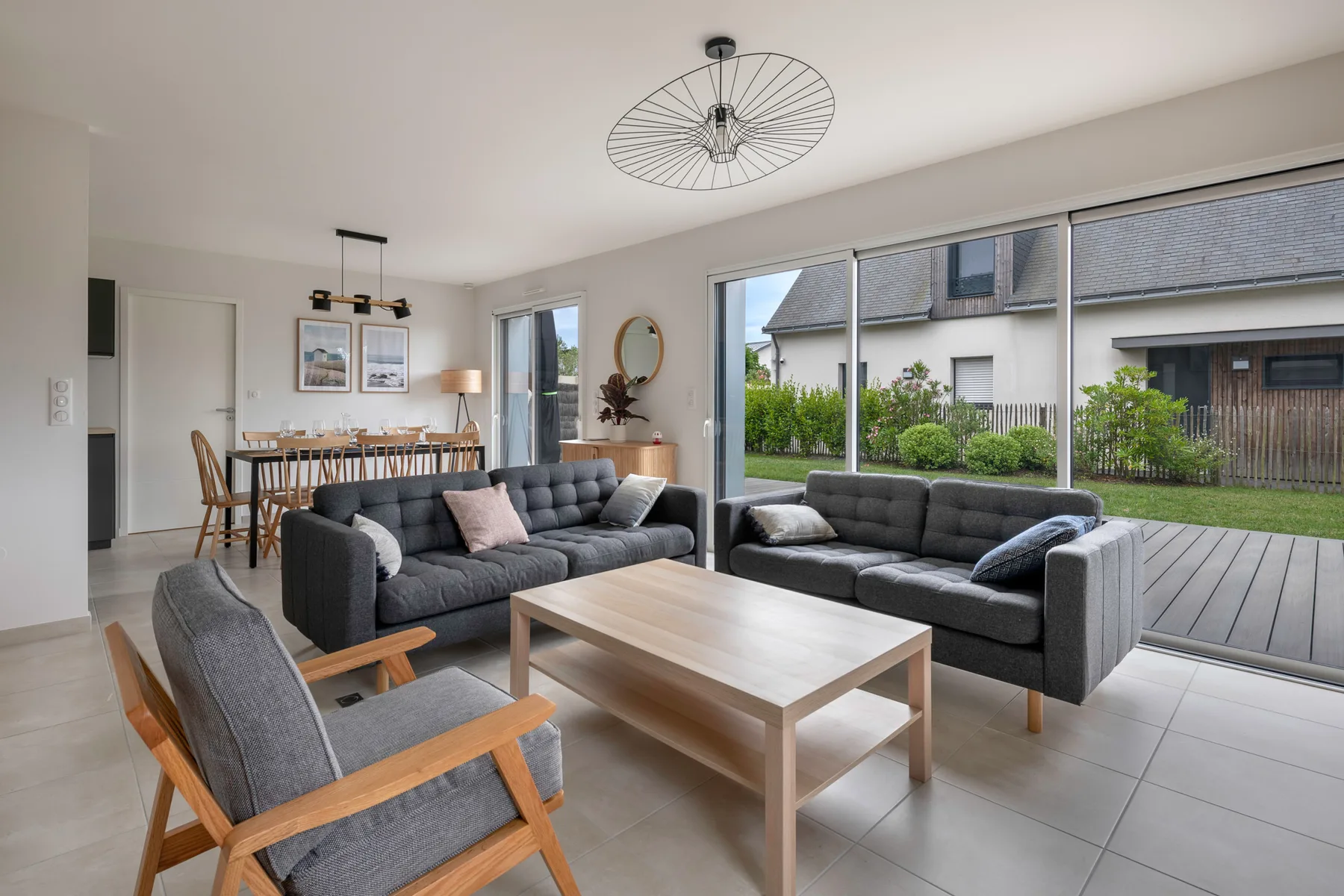 A bright living room with seating and a large window overlooking a patio.
