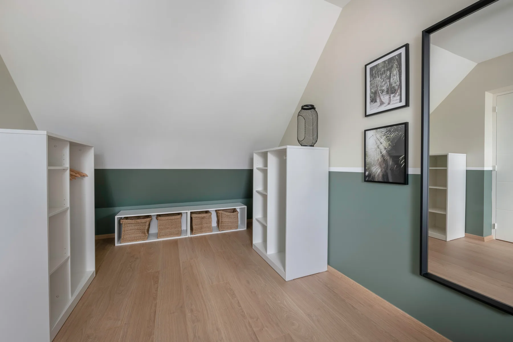 A bright room with white storage shelves and framed pictures on the wall.