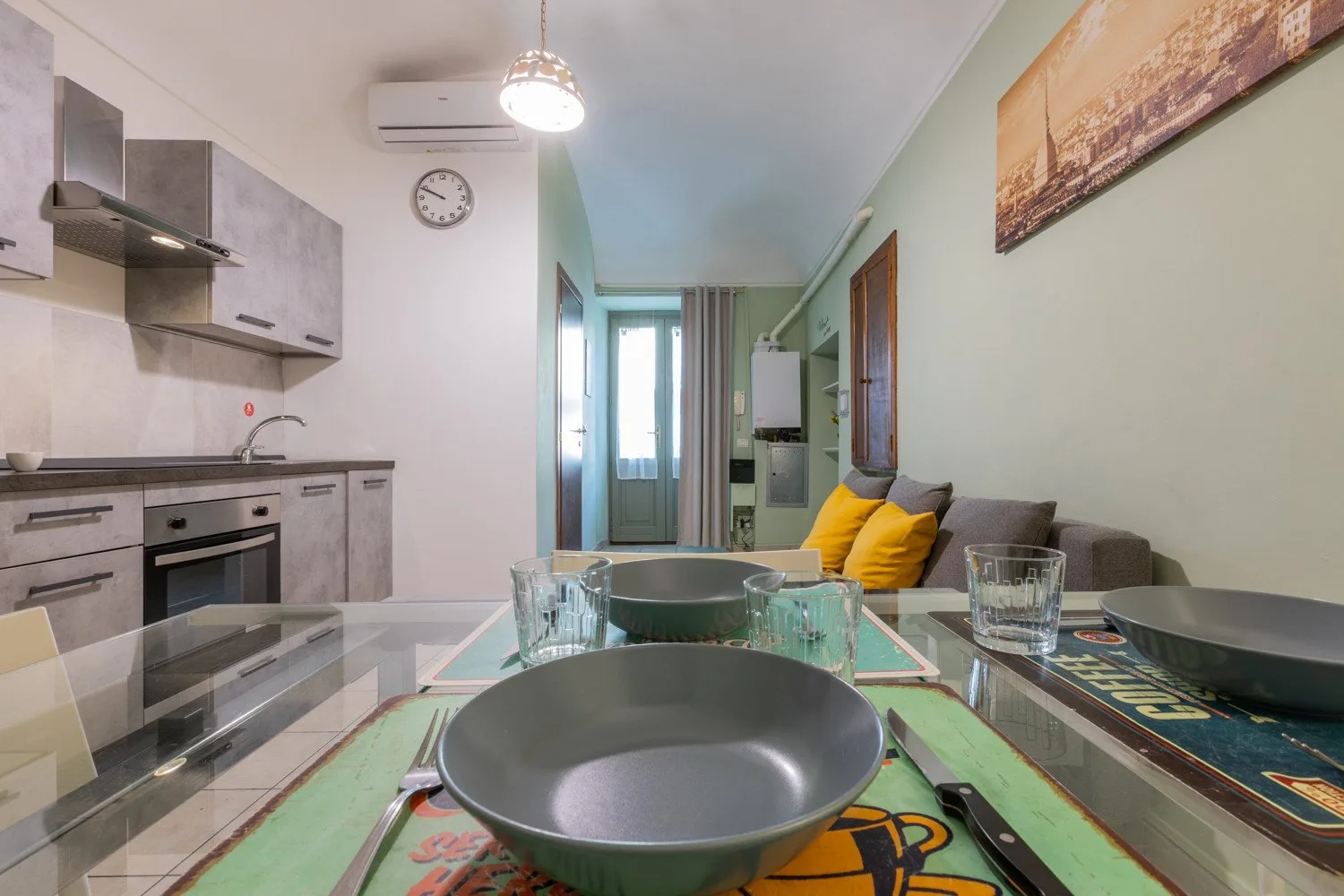 Una cocina integrada con sala de estar y platos sobre la mesa.
