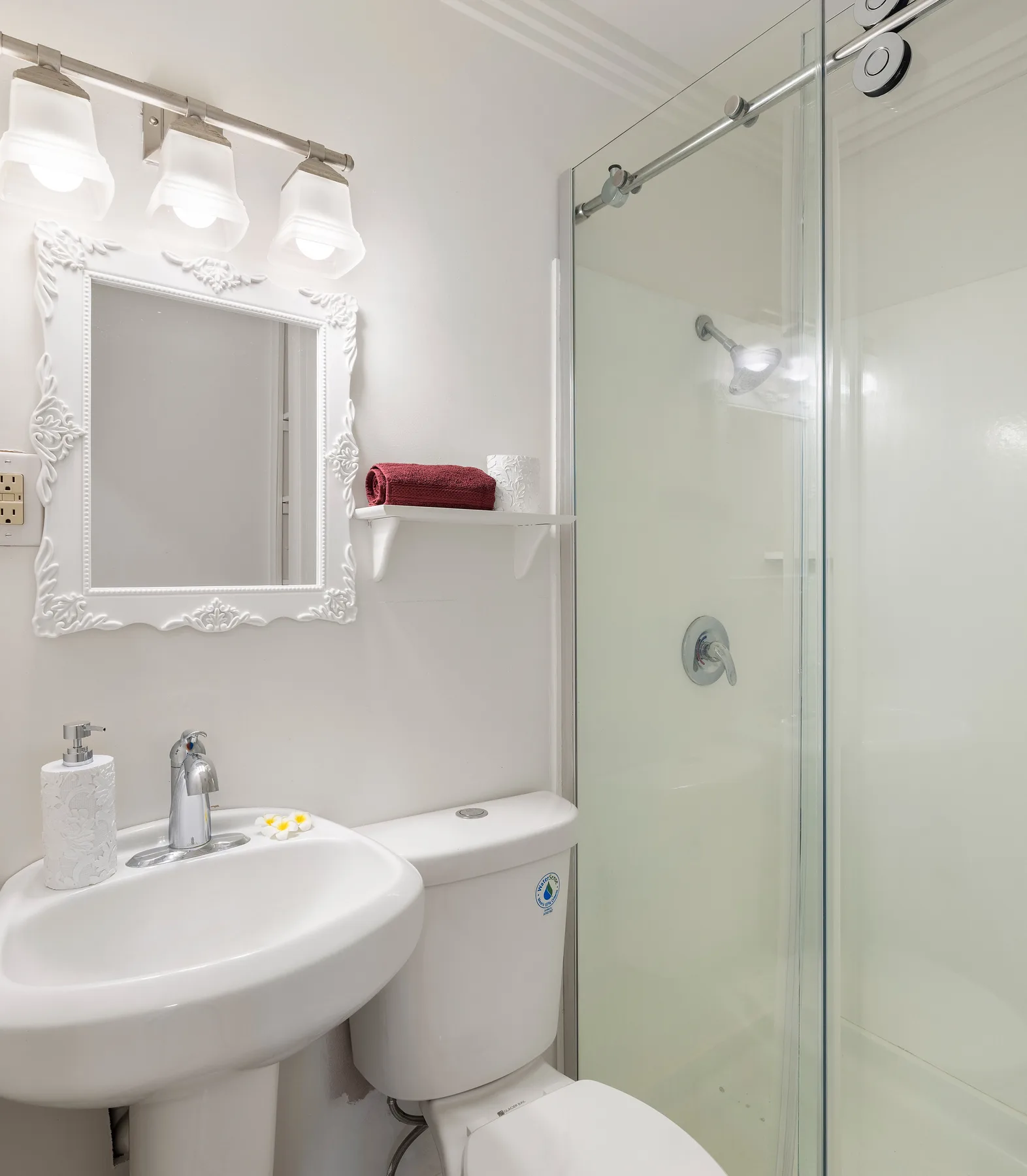 A bathroom with a sink, toilet, and glass shower.