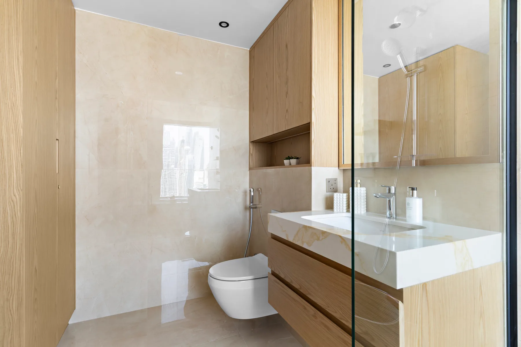 Un baño moderno con ducha de vidrio, lavabo e inodoro.